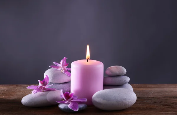 Spa stones with burning candle and flowers