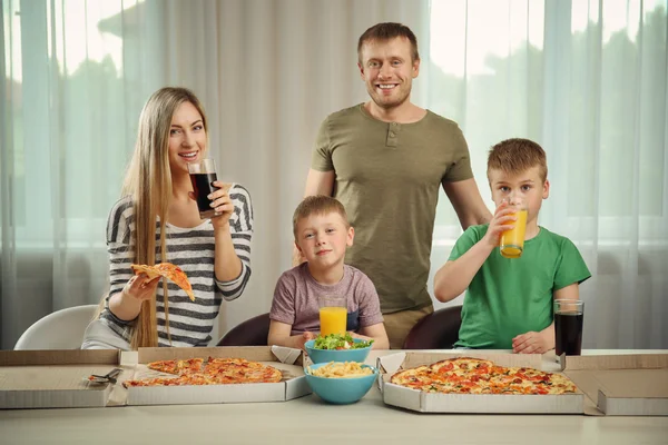 Happy family eating pizza