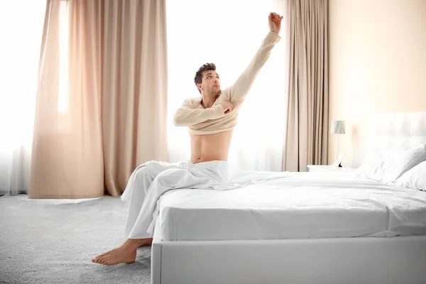 Young man waking up in bed