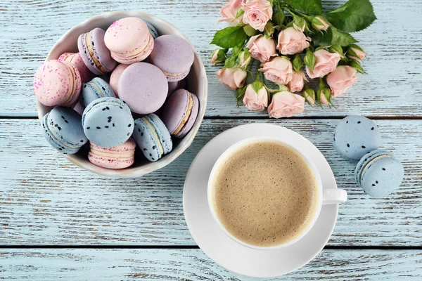Cup of coffee with macaroons and roses