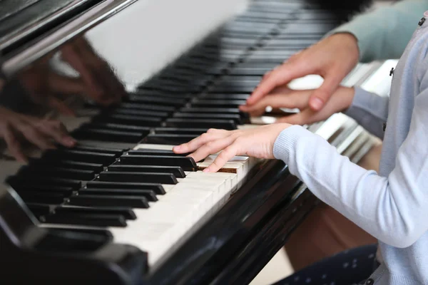 Small girl learning play piano