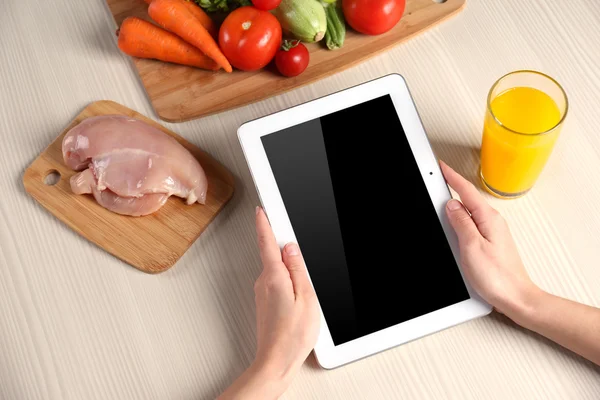 Woman reading recipe from tablet