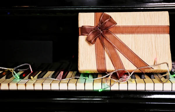 Christmas gift box on piano keys, closeup