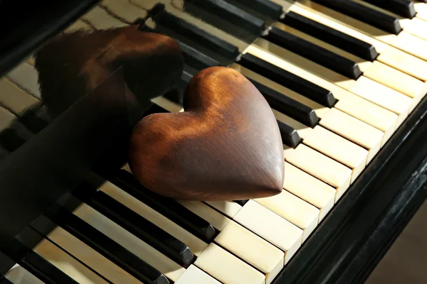 Brown heart on piano keys, close up