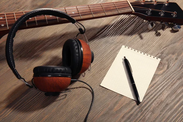 Headphones, guitar and notebook