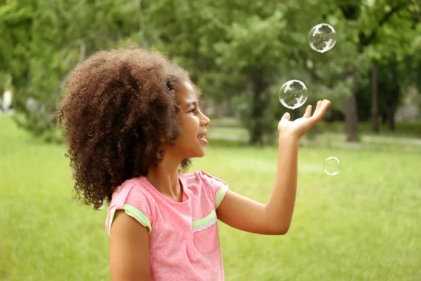 Little girl catching soap bubbles