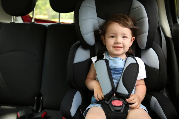 Boy sitting in a car in safety chair