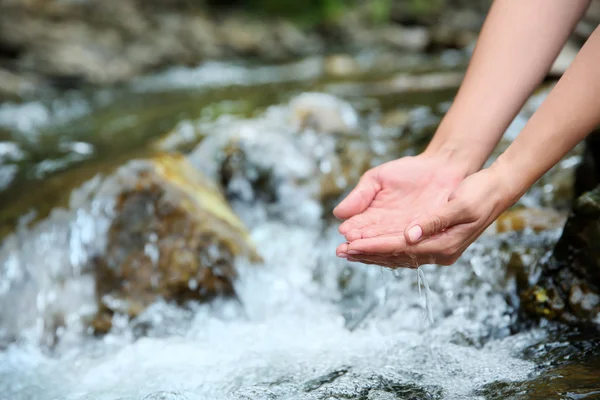 Hands in water stream