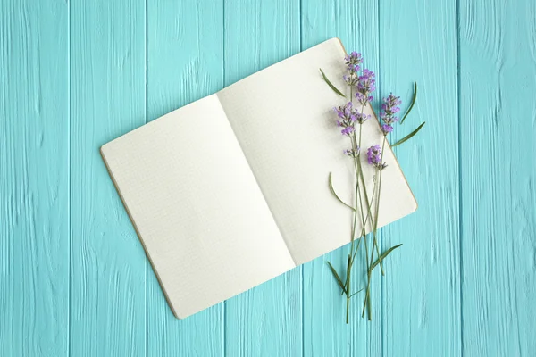 Lavender with notebook on wooden background