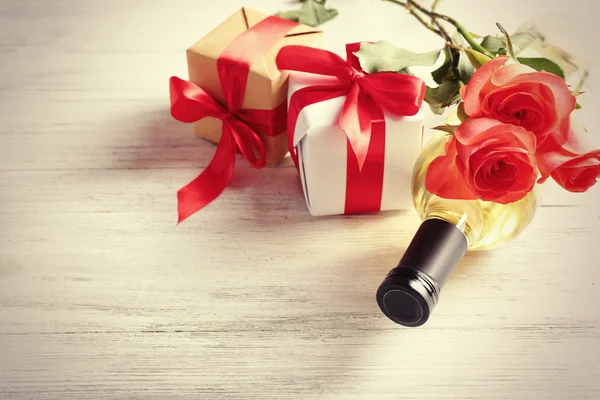 Bottle of wine, gift boxes and roses