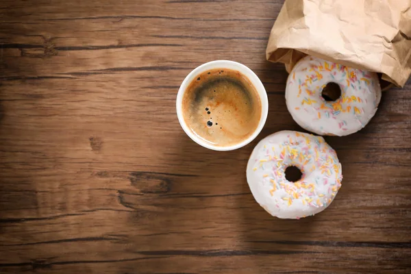 Paper cup of coffee and doughnuts