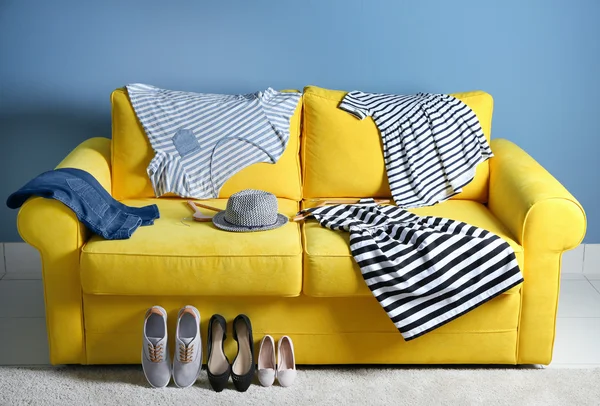 Family clothes on yellow sofa