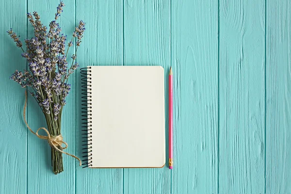 Lavender with notebook on wooden background