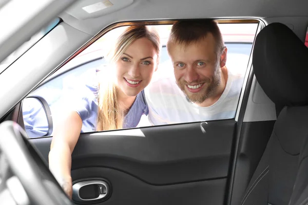 Young couple looking inside car