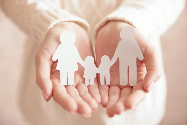 Female hands with paper family.