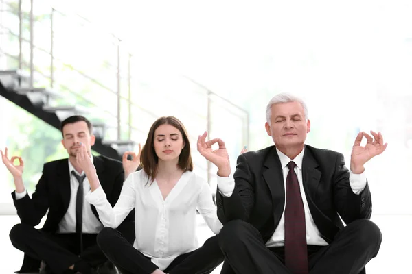 Business people relaxing in meditation pose
