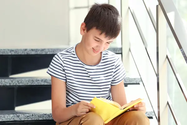 Cute boy reading book