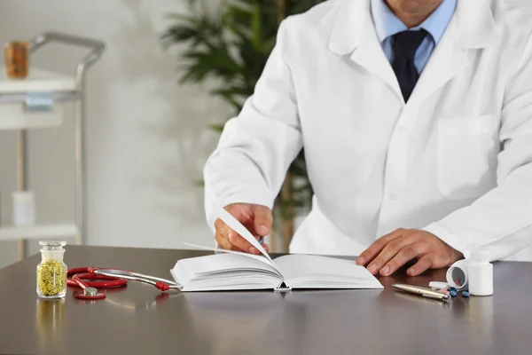 Male doctor with medical recipe book