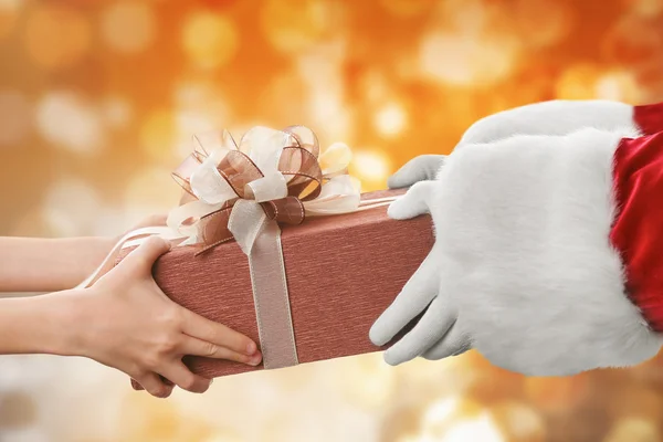 Santa hands give present to kid