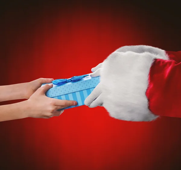 Santa hands give present to kid