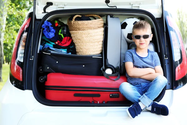 Cute little boy sitting in car