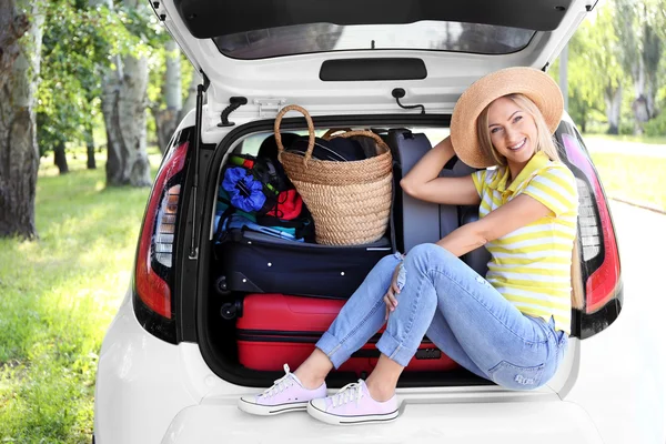 Woman near car trunk