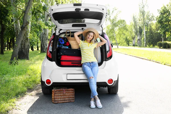 Woman near car trunk