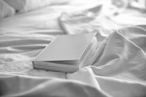 Closed book on white crumpled sheet