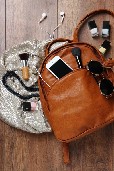 Brown leather backpack with female items