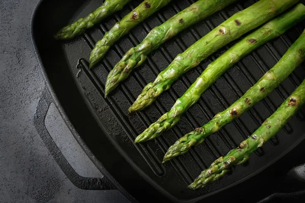 Fresh asparagus on frying pan