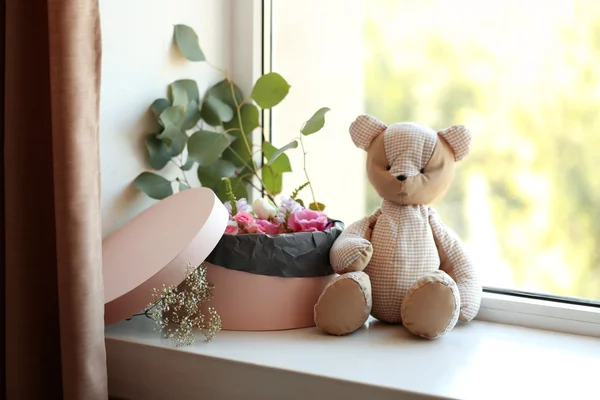 Box with fresh flowers and teddy bear