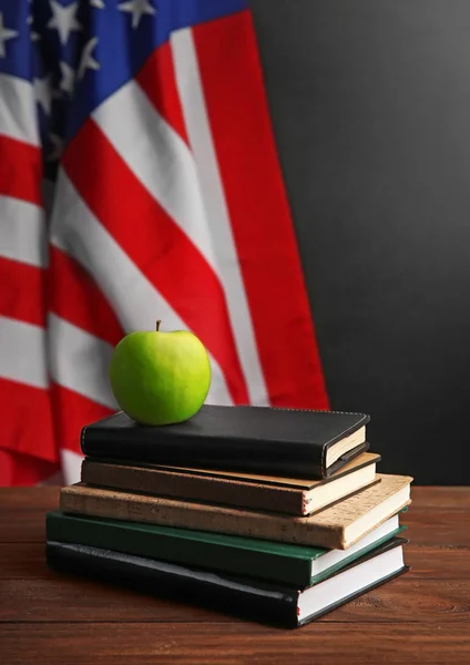 Books with apple on American flag