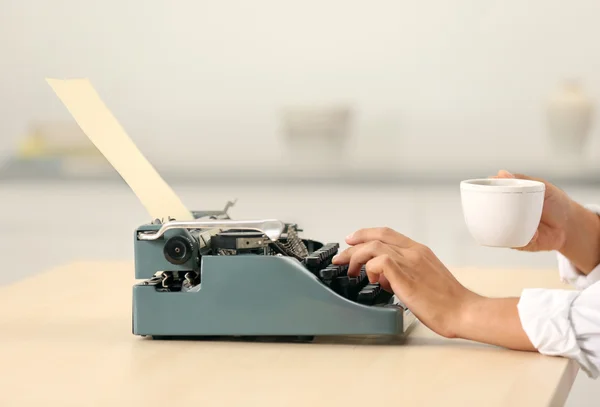 Man working on retro typewriter at desk