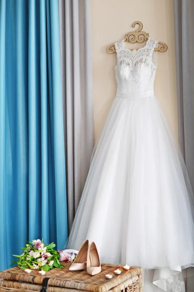 Shoes on wicker chest and wedding dress