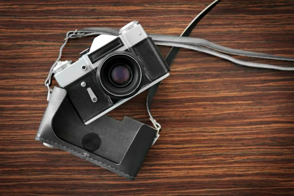 Vintage camera with case on wooden background