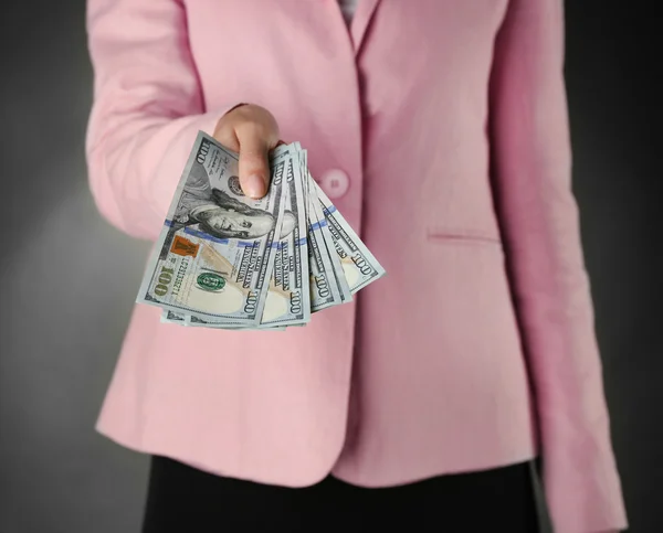 Woman with money on dark background