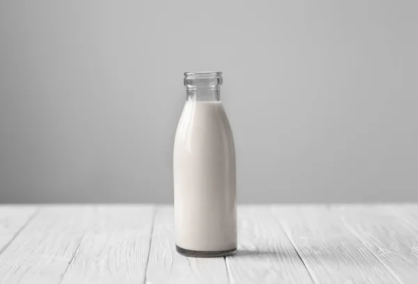 Bottle of fresh milk on white wooden table