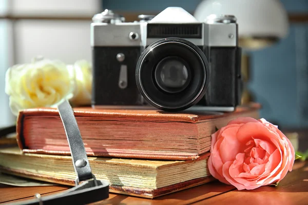 Vintage camera and beautiful roses on photo albums