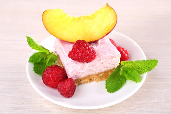 Cake with fruits and berries on plate on wooden background