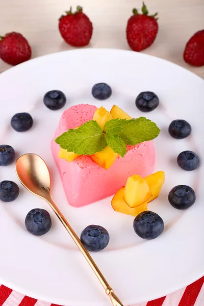 Heart shaped cake with fruits and berries on plate on napkin