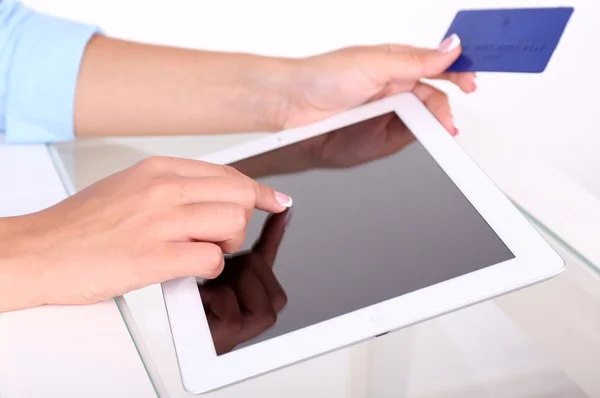 Woman using digital tablet and holding credit card in her hand. On-line shopping concept