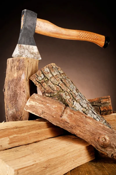 Firewood and axe on floor on dark background