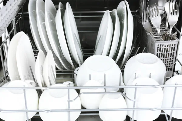 Open dishwasher with clean utensils in it