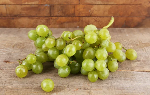Green grape on wooden table on wooden background