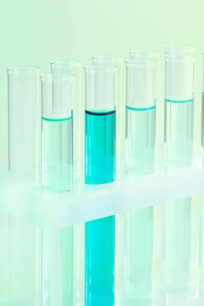 Test-tubes with blue liquid on light background