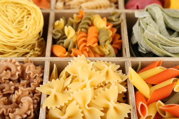 Colorful pasta in wooden box, close-up