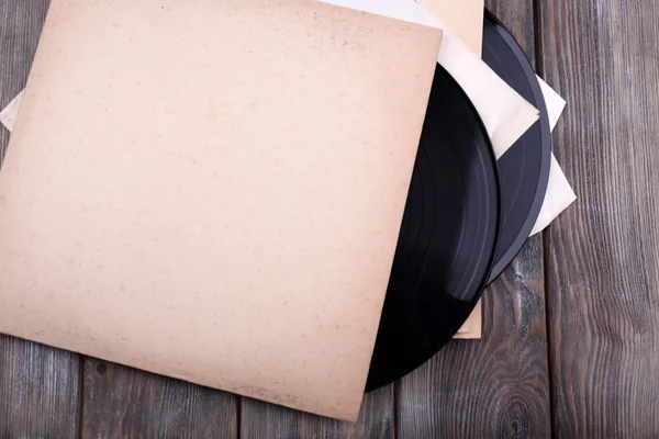 Vinyl records records and paper covers on wooden background