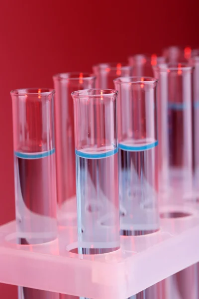 Test-tubes with blue liquid on purple background