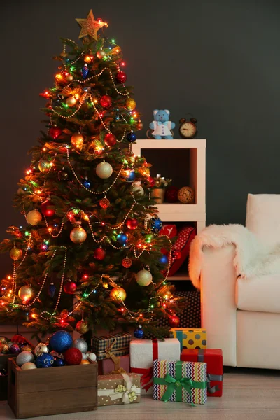 Decorated Christmas tree on home interior background at night