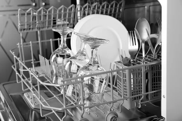 Open dishwasher with clean utensils in it